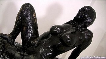 Mindy mink covered in black grease in front of mirror solo